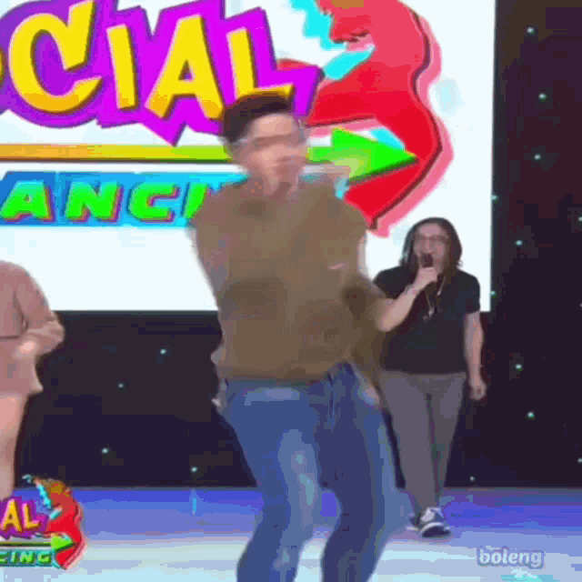 a man is dancing in front of a screen that says cial