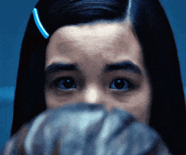 a close up of a girl 's face with a blue hair clip in her hair