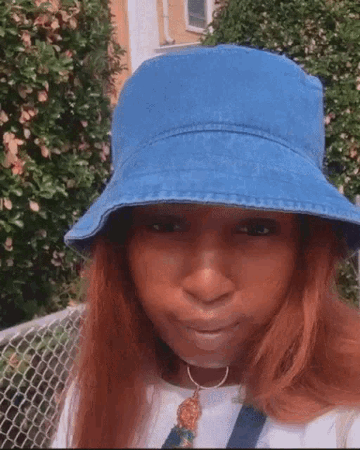 a woman wearing a blue bucket hat and a necklace