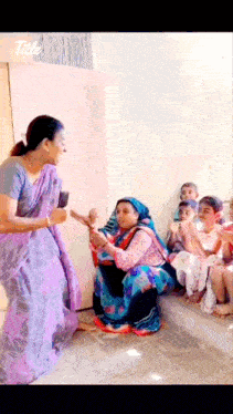 a woman in a purple dress is talking to a group of children