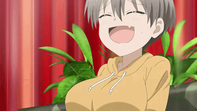 a girl in a yellow hoodie is laughing with her eyes closed