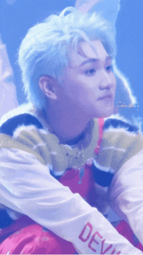 a boy with blue hair is wearing a shirt that says devil on the sleeve