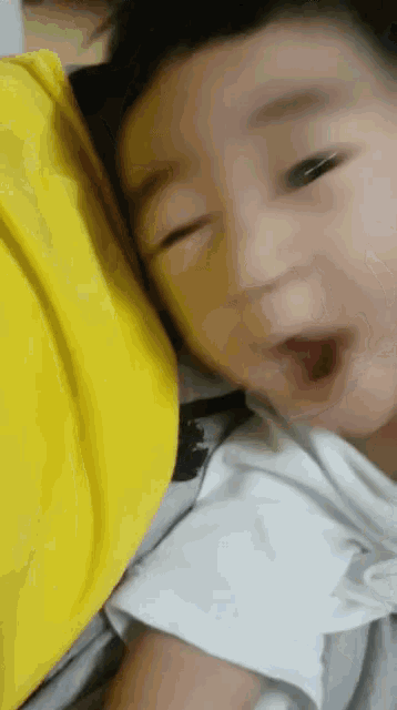 a close up of a baby laying on a bed with his mouth open