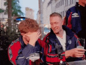 a group of young men are sitting at a table drinking beer .