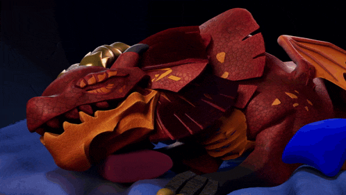a red and gold dragon is laying down on a blue surface