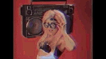 a woman is standing in front of a boombox .