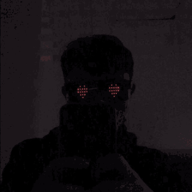 a man wearing heart shaped sunglasses is taking a selfie
