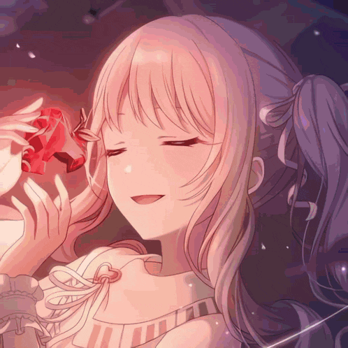 a close up of a girl with her eyes closed holding a red object