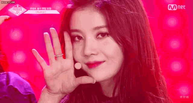 a close up of a woman 's face with her hand up in the air .