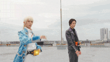 a man in a blue coat is standing next to another man in a purple jacket