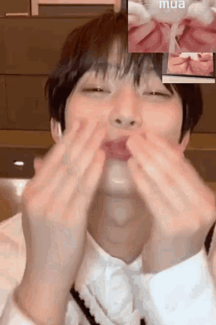 a young man is making a funny face while talking on a video call with another person .