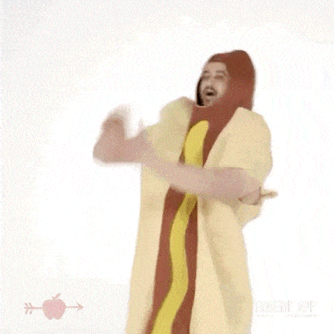 a man in a hot dog costume is dancing and making a funny face .