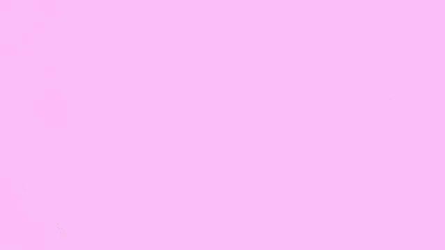a man wearing glasses is sitting in a gaming chair with pink bubbles coming out of his mouth .