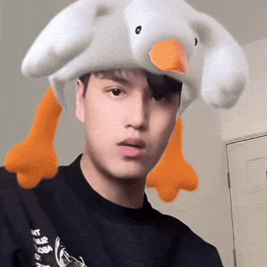 a young man wearing a stuffed duck hat with orange legs