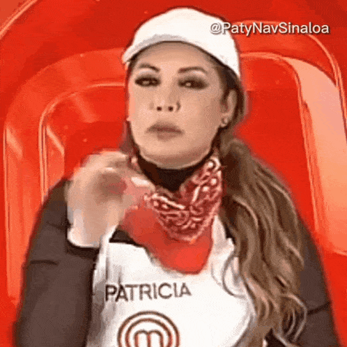 a woman wearing a white hat and a red bandana is sitting in a chair .