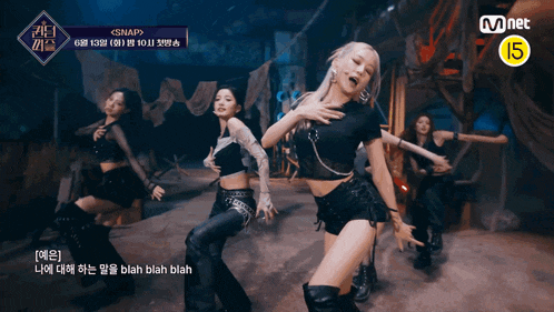 a group of women are dancing in front of a mnet sign