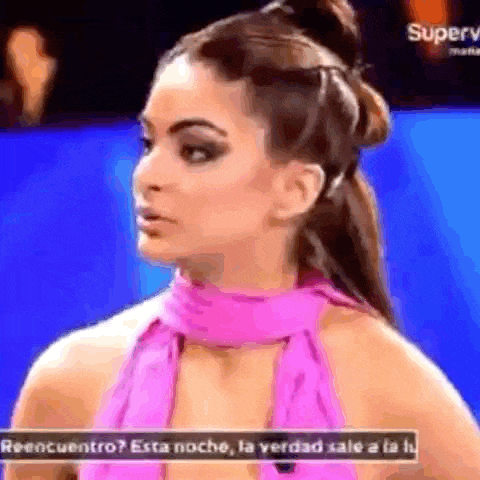 a woman in a pink dress is talking to someone on a television show .