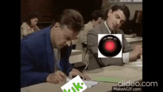 a group of people are sitting at a table with a red light in the background .
