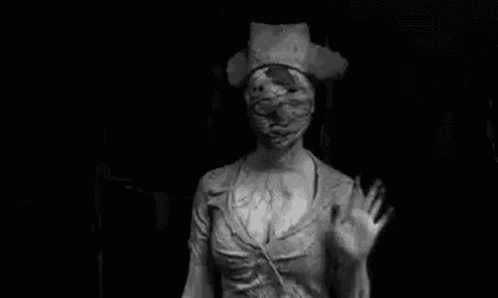 a black and white photo of a scary nurse waving .