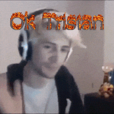 a man wearing headphones with the word ok tristan written in flames