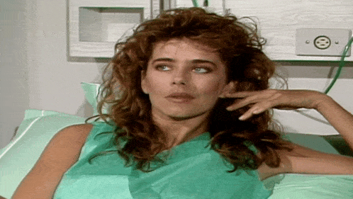 a woman in a hospital gown is laying in a bed