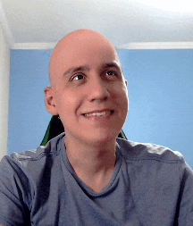 a bald man wearing a blue shirt is smiling for the camera