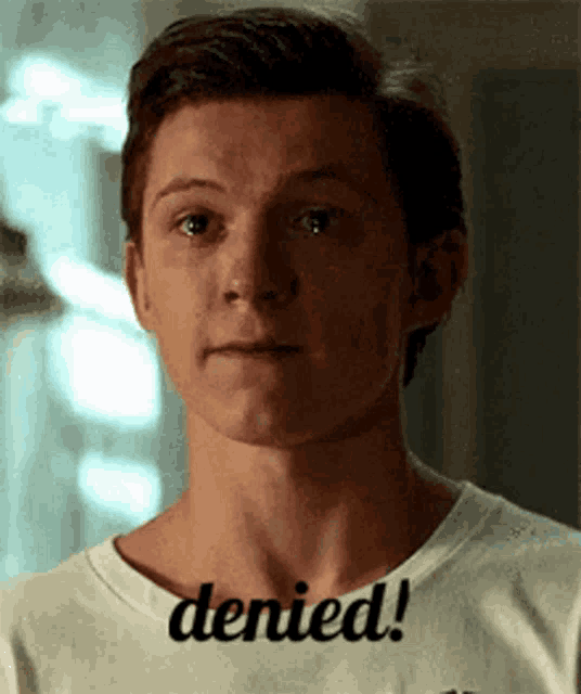 a young man is wearing a white shirt that says denied .