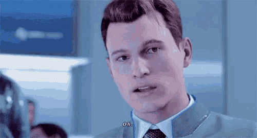 a man in a suit and tie is talking to another man in a room .