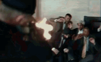 a man in a top hat is holding a torch in front of a group of men in suits