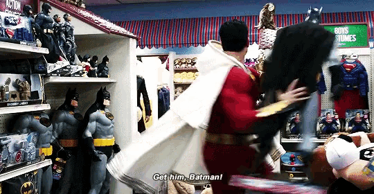 a man in a batman costume is talking to a man in a superman costume