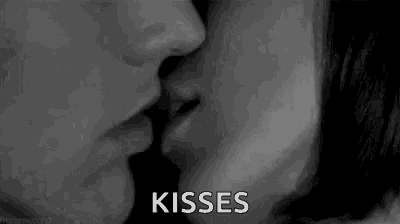 a black and white photo of a man and woman kissing .