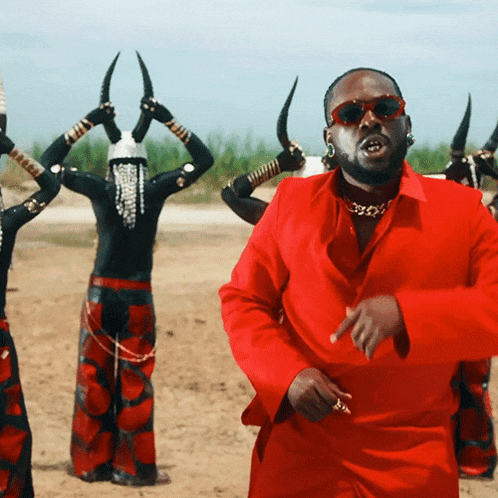 a man in a red suit is standing in front of a group of people