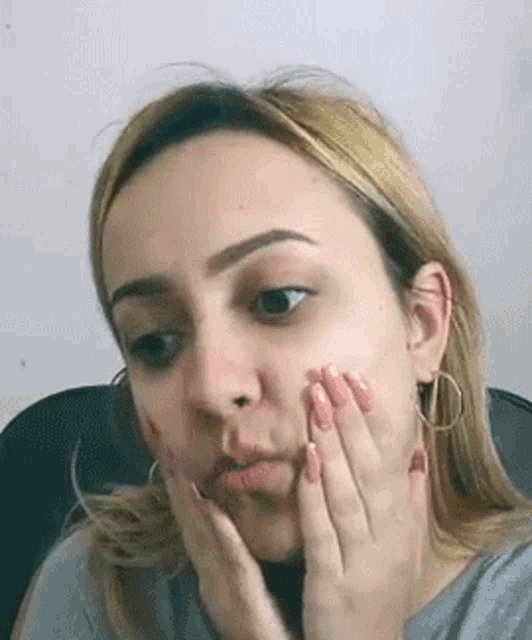 a woman is covering her face with her hands .