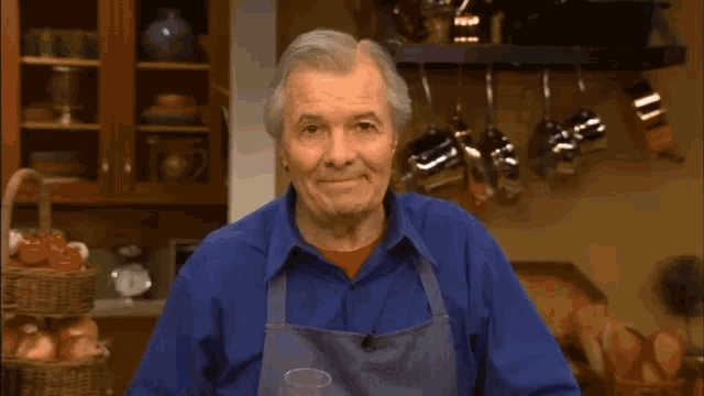 a man in an apron says happy cooking in front of a kitchen