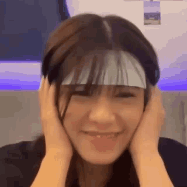 a woman with a bandage on her head is smiling .