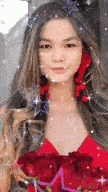 a woman is holding a bouquet of red roses in her hand .