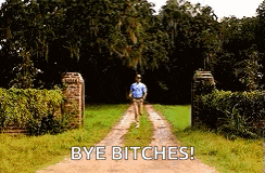 a man is walking down a dirt road with the words `` bye bitches '' above him .