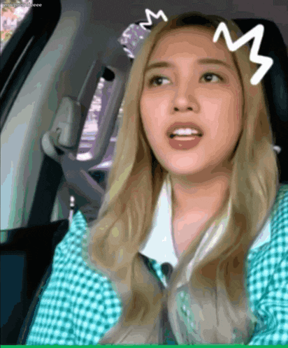 a woman in a car with a white m on her forehead