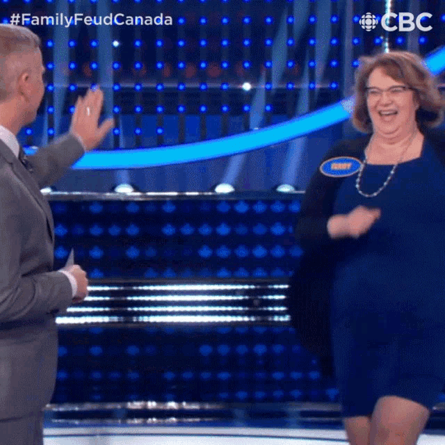 a woman in a blue dress is on a tv show called family feud