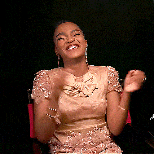 a woman in a dress with a bow on the front is smiling
