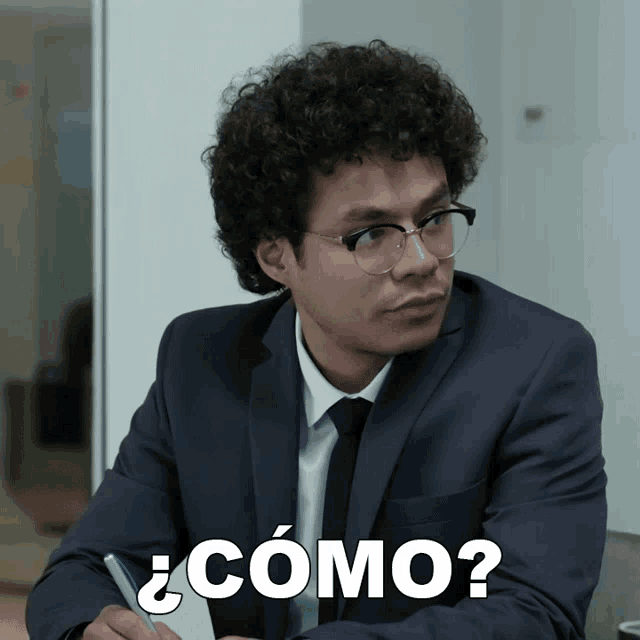a man in a suit and tie is sitting at a desk with a pen in his hand and the words ¿ como ? above him