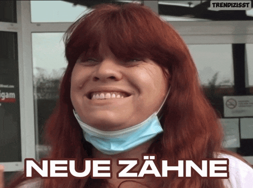 a woman with red hair is wearing a face mask and smiling with the words neue zähne behind her