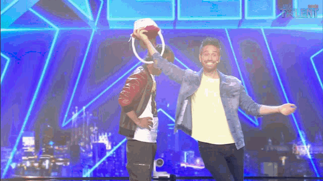 two men are dancing on a stage in front of a blue background with the word talent on it