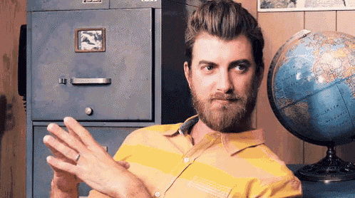 a man with a beard is sitting in front of a filing cabinet and a globe ..