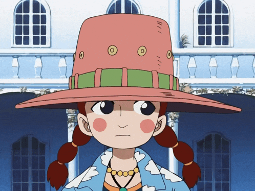 a girl wearing a pink hat with circles on it stands in front of a building