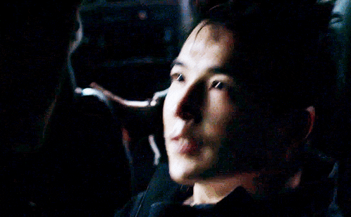 a close up of a man 's face in a dark room looking down .