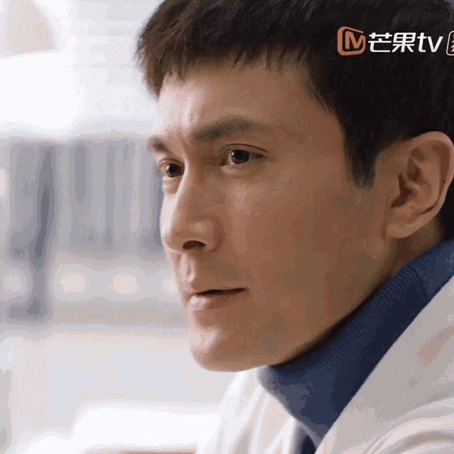 a close up of a man 's face with a chinese tv logo in the corner