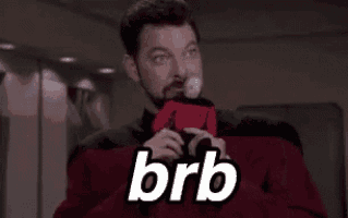 a man with a beard is holding a ball and the word brb is on his shirt .