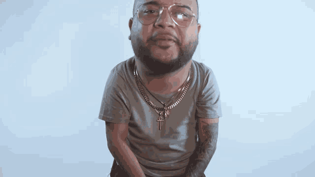 a man with glasses and a necklace with a cross on it