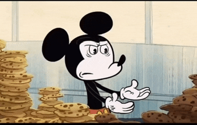 a cartoon mickey mouse is standing in front of a pile of cookies